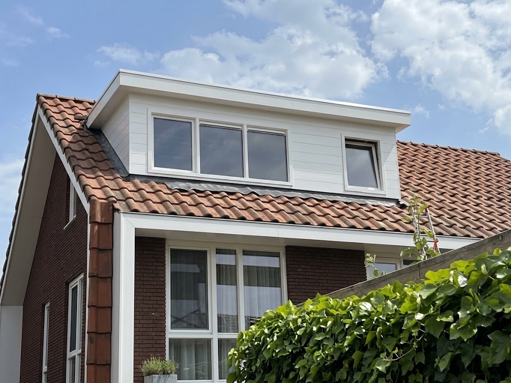 Witte dakkapel over de volle breedte op een rood pannendak aan de Mambohof in Apeldoorn