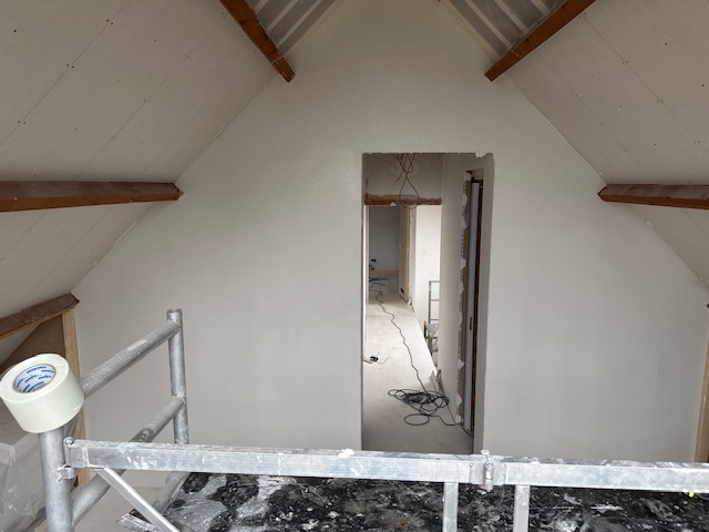 Glad gestucte wanden en plafond op een zolder in Apeldoorn